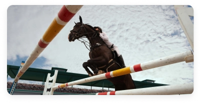 Cavalo e cavaleiro a ultrapassar um obstáculo durante uma prova